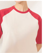 Modelo vestindo Camiseta Raglan Off White e Vermelha