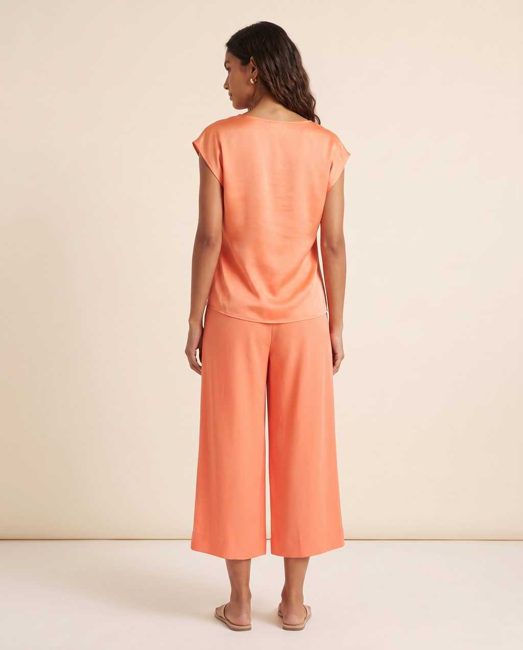 Modelo vestindo Blusa Cetim Laranja, de costas