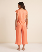 Modelo vestindo Blusa Cetim Laranja, de costas