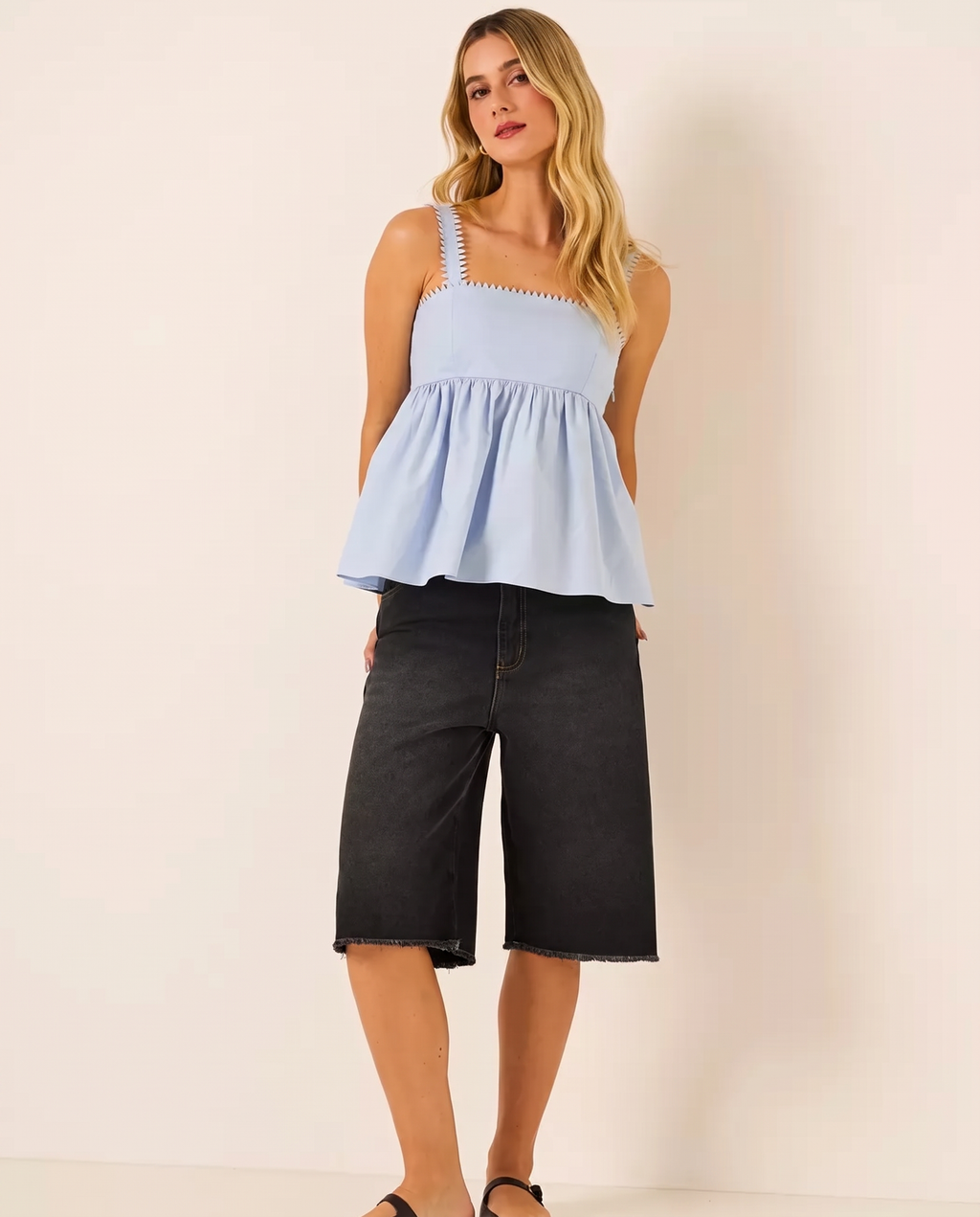 Modelo vestindo Bermuda Pespontada em Jeans Preto